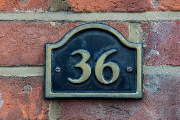 istock The house number 36 in brass on a red brick wall, 1085600942