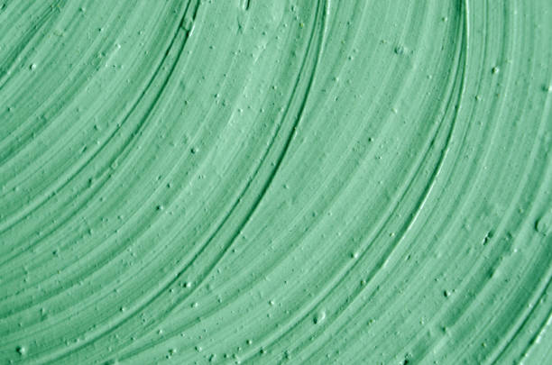 istock Green cosmetic clay (facial mask, cream, body scrub) texture close up, selective focus. Abstract background with brush strokes. 1085614604