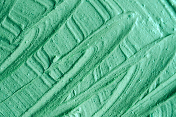 istock Green cosmetic clay (facial mask, cream, body scrub) texture close up, selective focus. Abstract background with brush strokes. 1085614666