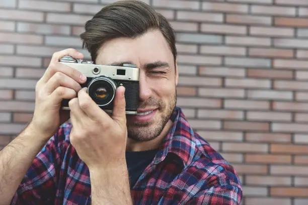 Photo of Say cheese, hipster fashion photographer man holding retro camera