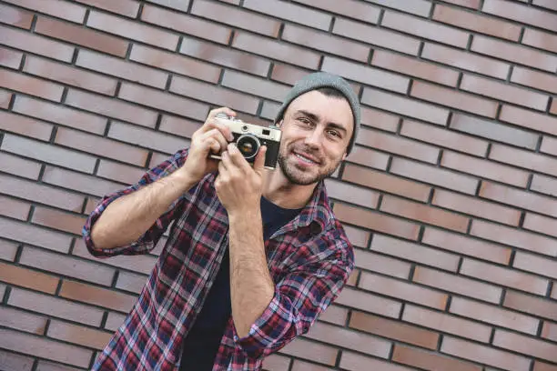 Photo of Say cheese, hipster fashion photographer man holding retro camera