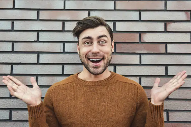 Photo of Close up Happy Handsome Man in Trendy Fashion Leaning on Old Brick Wall While Looking at the Camera.