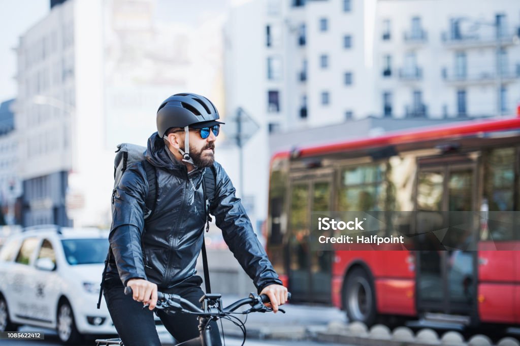 Hombre Mensajero con bicicleta entregando paquetes en la ciudad. Copia espacio. - Foto de stock de Bicicleta libre de derechos