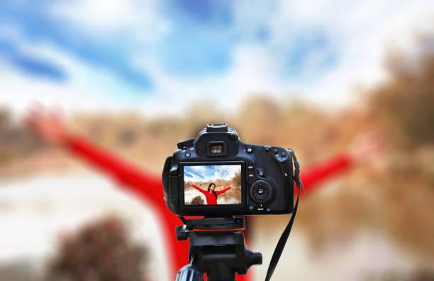 Camera taking portrait ot teenager girl outdoor in nature.