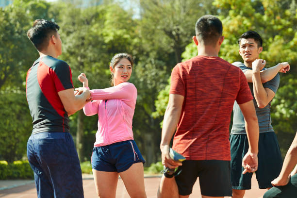 istock young asian athletes stretching arms and legs 1085627166