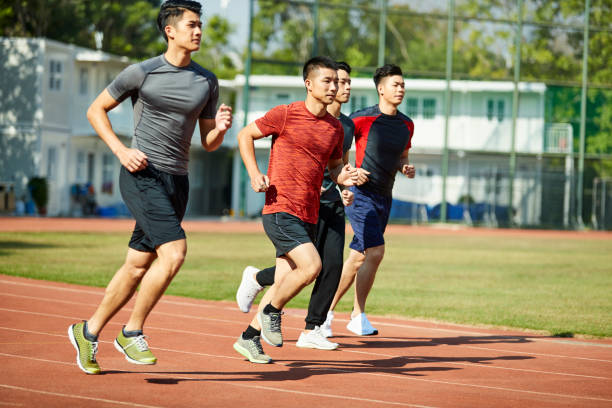 istock young asian athletes running racing on track 1085627196