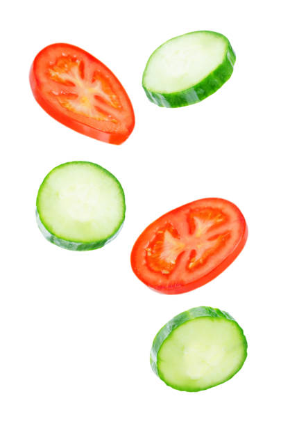 Flying Cucumber slices with tomato slices stock photo