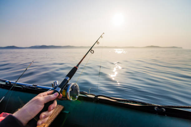 istock Fish-rod in fishermen's hand 1085632138