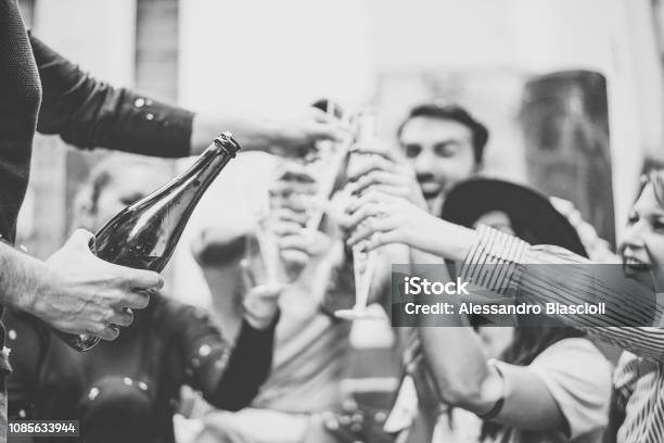 Multiracial Group Of Young Friends Having Fun Drinking And Toasting Glasses Of Champagne On University Stairs Happy People Celebrating Graduation With A Bottle Of Prosecco In City Outdoor Stock Photo - Download Image Now
