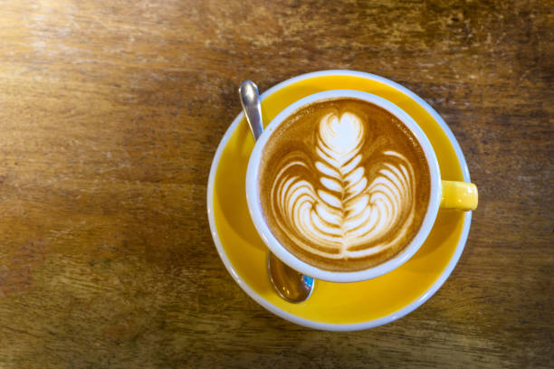 istock Coffee in yellow coffee cup and on a wood background 1085638890