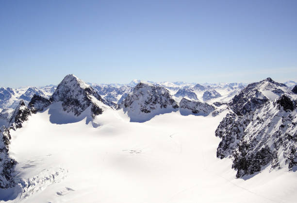 berg-winterlandschaft in der silvretta-gebirgskette in den schweizer alpen mit berühmten piz buin mountain peak in der mitte - silvretta stock-fotos und bilder