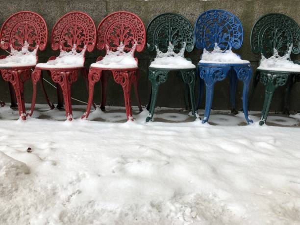 istock Old Chairs in different color in snow winter daylight. 1085663426