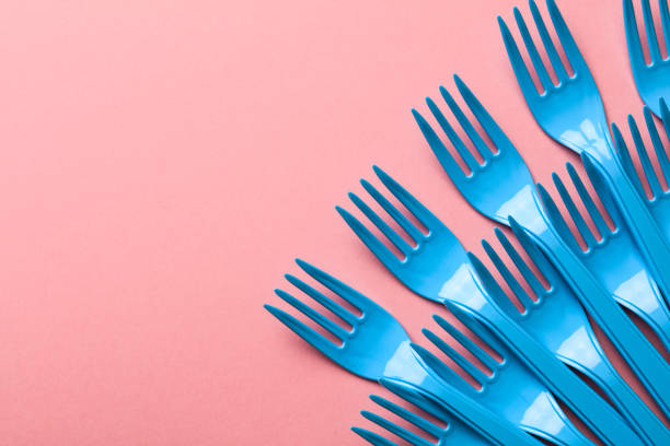 Close-up of blue forks on pink background