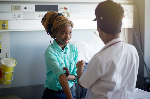 An African young Female Doctor taking blood pressure on a young patient with a headscarf Cape Town South Africa