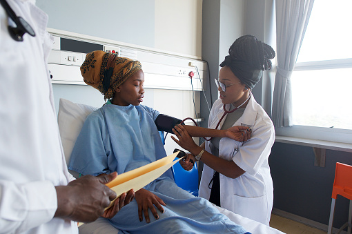 Mujer médico tomando la presión arterial en el paciente en un hospital photo
