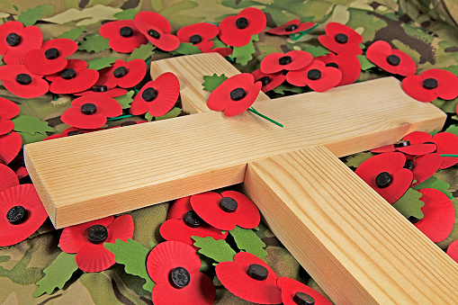 Remembrance day poppies surrounding a wooden cross