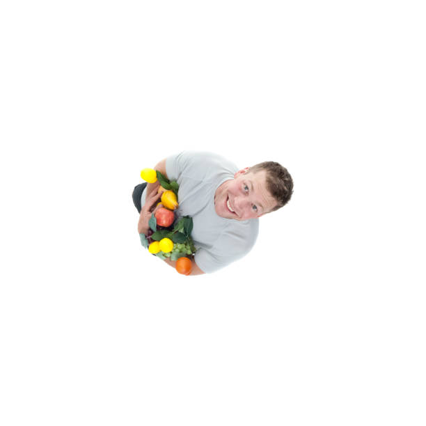 Directly above view of regular man holding a variety of fruits