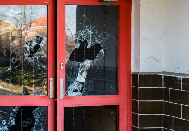 broken window in an old abandoned building secured with a wooden board.