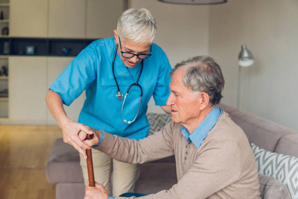 istock Nurse helping patient with a cane 1085697538
