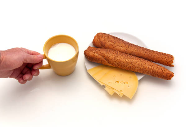 Toasted bread with kaya and butter spread, served with soft-boiled eggs and a cup of milk tea, an authentic Malaysian breakfast.