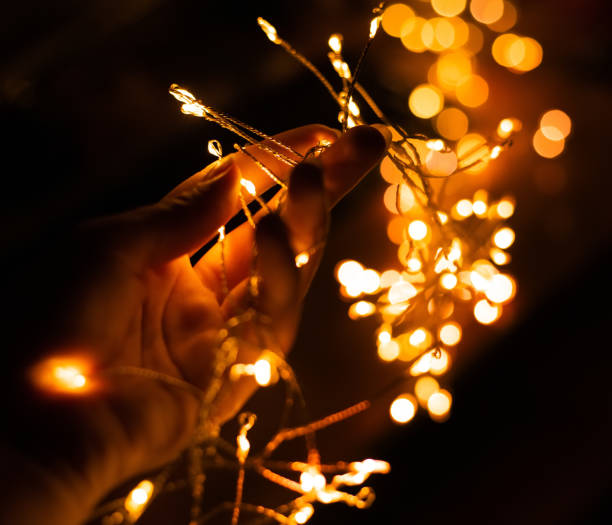 istock Girl's hand holding LED flashlights on a black background with bokeh 1085710784