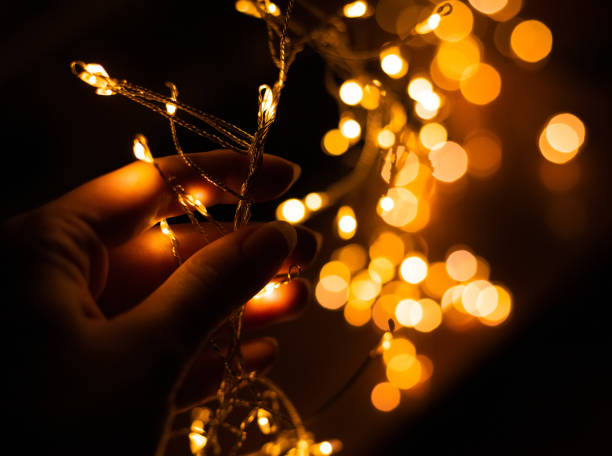 istock Girl's hand holding LED flashlights on a black background with bokeh 1085710794