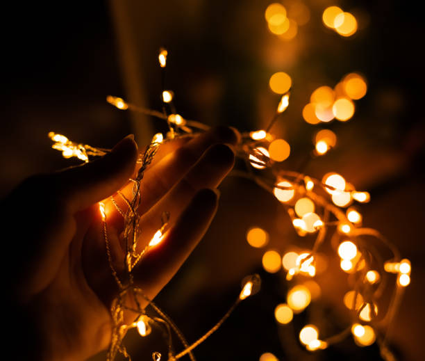 istock Girl's hand holding LED flashlights on a black background with bokeh 1085710826