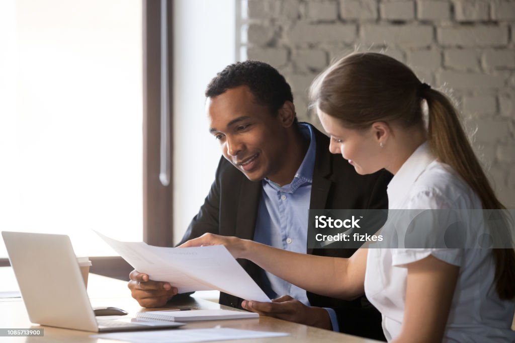 Female financial advisor insurer consulting male african-american client about contract Female financial advisor insurer banker consulting male african american client about contract, caucasian mentor hr and black intern new employee discussing documents at meeting advice Benefits Stock Photo