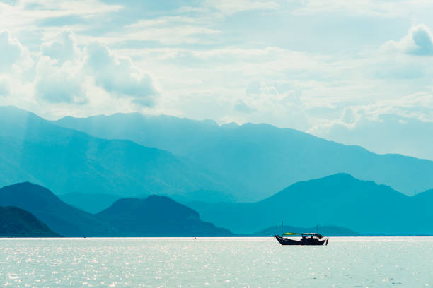 Lonely boat in the sea against the backdrop of the mountains.