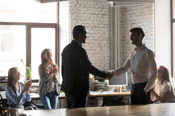 istock Smiling african ceo promoting motivating successful caucasian worker shaking hands 1085713972