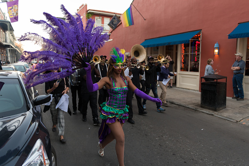 New Orleans, USA - Nov 3, 2018: A woman in a Second Line moving down Bourbon street in the french quarter late in the day.