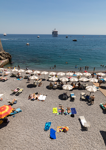 Amalfi, Italy - June 13, 2017: People are resting on a sunny day at the beach in Amalfi on Amalfi Coast in the region Campania, Italy