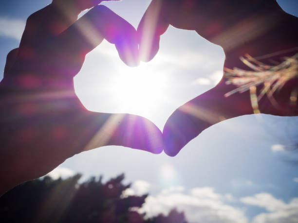 istock Boy hands form a heart against the sun beams. 1085726940