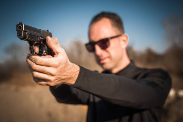 istock Police agent bodyguard gun pointing pistol to attacker. Front view 1085735872