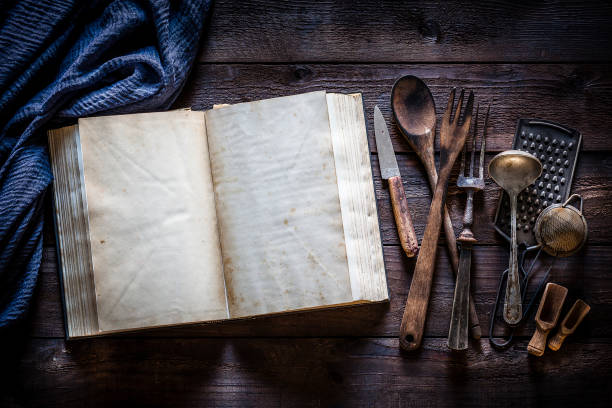 istock Vintage cookbook with kitchen utensils on rustic wooden table 1085741068