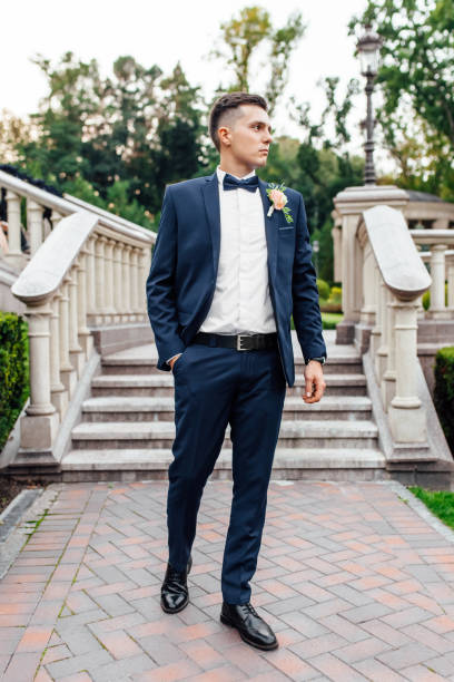 istock the groom in a wedding suit, posing in nature 1085743802