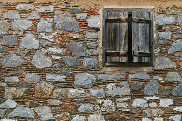 istock Old naturel stone wall with an antique wooden window 1085745882