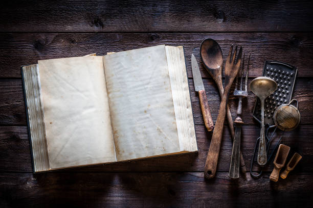 istock Vintage cookbook with kitchen utensils on rustic wooden table 1085747036