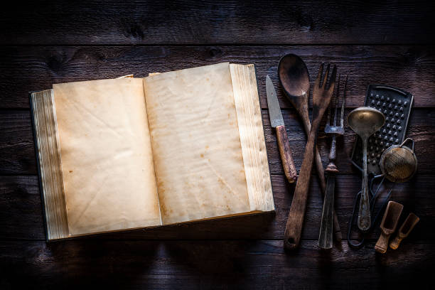 istock Vintage cookbook with kitchen utensils on rustic wooden table 1085750808