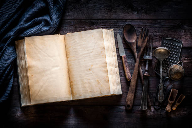 istock Vintage cookbook with kitchen utensils on rustic wooden table 1085750816