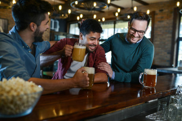 istock Group of happy friends drinking beer and talking in a bar after work 1085758730