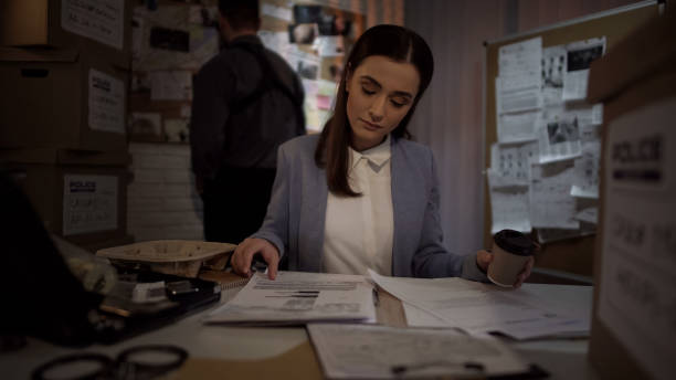 poliziotto donna con caffè esame caso, lettura testimonianze dichiarazioni, lista prove - police statement foto e immagini stock