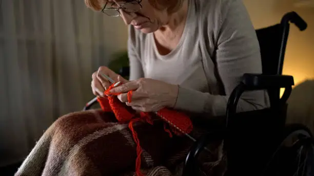 Senior woman feeling desperate of bad sight to knit, eye-illness, hopelessness