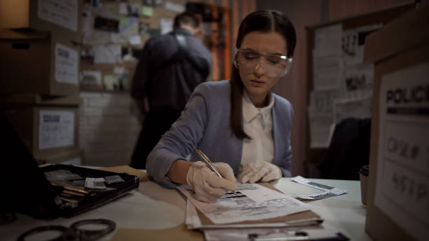 istock Lady detective checking criminal fingerprints database, examining evidence 1085793112