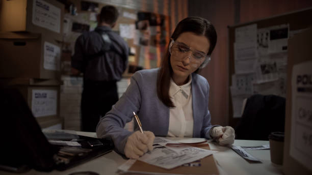 istock Experienced scientist looking at criminal scene photos, drawing conclusions 1085793136