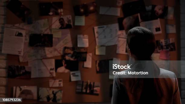 Lady Private Agent Looking At Crime Investigation Board Chasing Serial Killer Stock Photo - Download Image Now