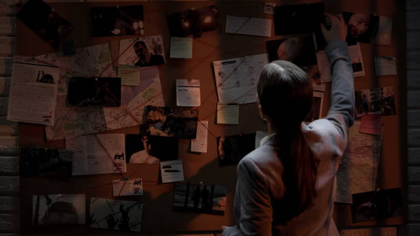 istock Smart detective looking attentively at investigation board, evaluating clues 1085793262