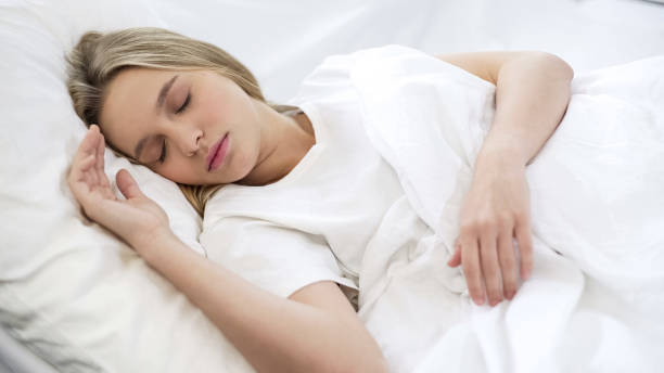 istock Young pretty female sleeping quietly in bed, comfortable orthopedic mattress 1085793266