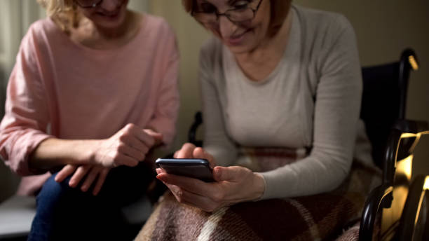 istock Friendly old woman learning how to use smartphone, daughter showing mobile apps 1085793386