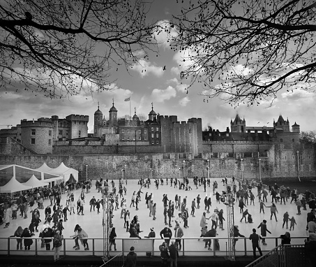 Black and white Christmas holiday ice skaters at Tower hill in front of The Tower of London the historic  Palace in central  London, UK